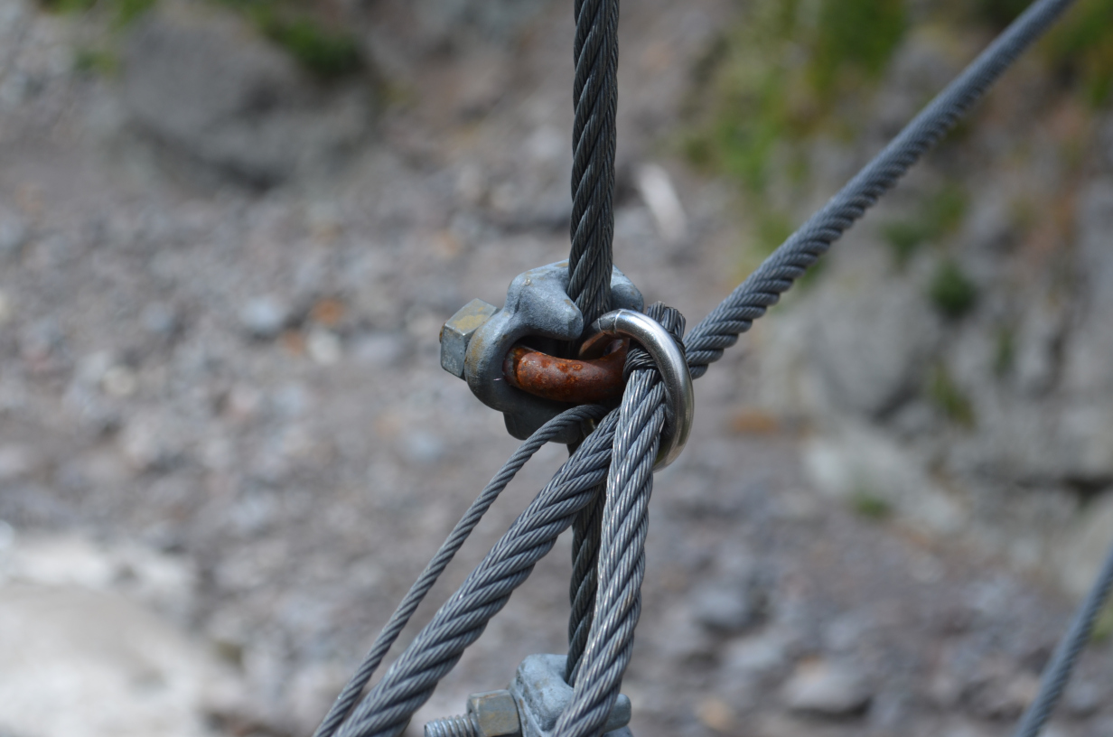 A small clamping u-bolt keeping the railing cables on.